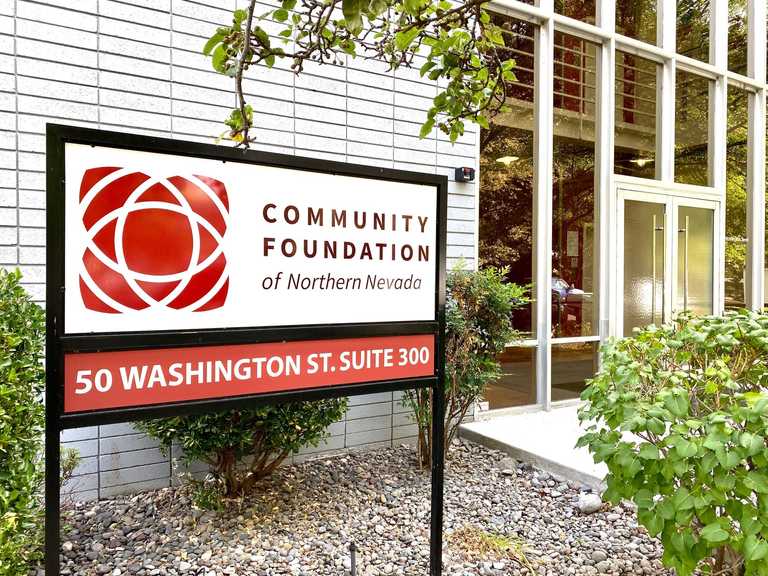 Red-and-white sign in front of the office building and door of the Community Foundation of Northern Nevada with 50 Washington Street Suite 300.