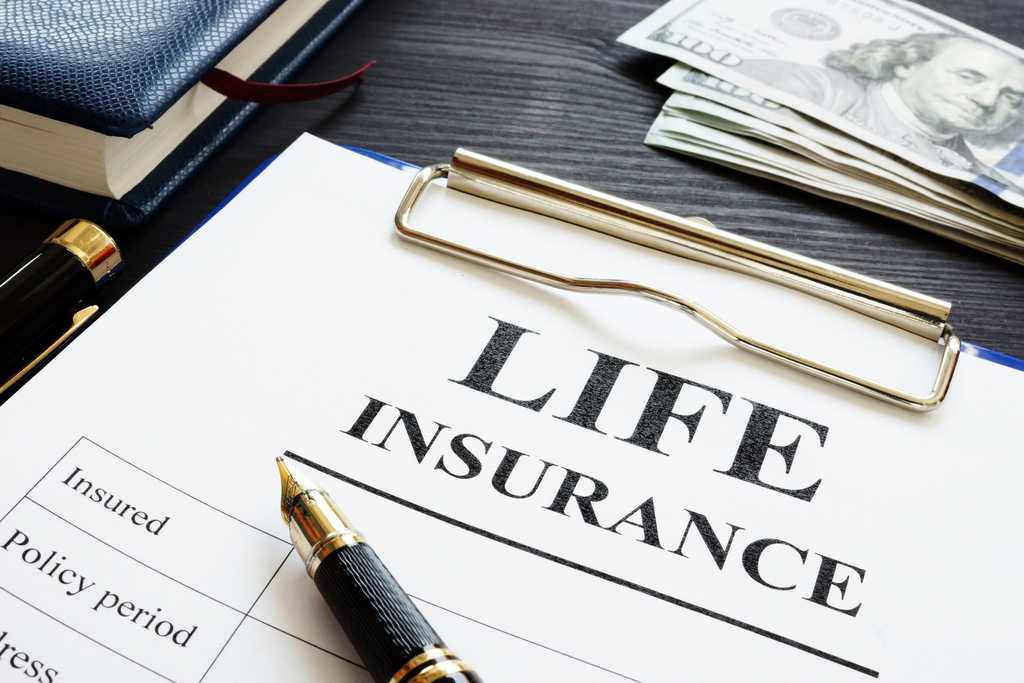 Clip board, pen,  $100 bills and paper labeled Life Insurance